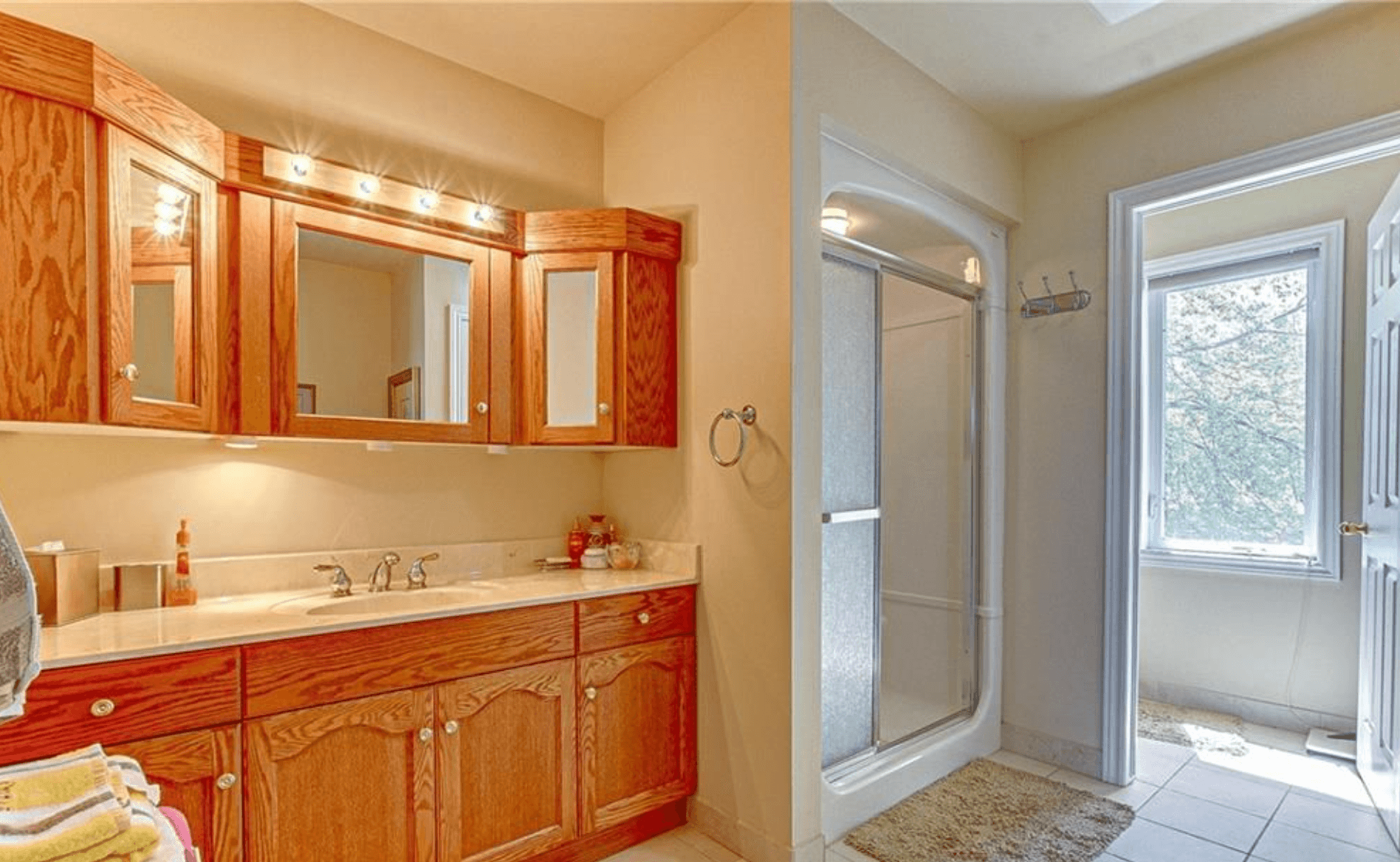 Bathroom with oak cabinets, a lighted mirror vanity, and a glass-door walk-in shower.